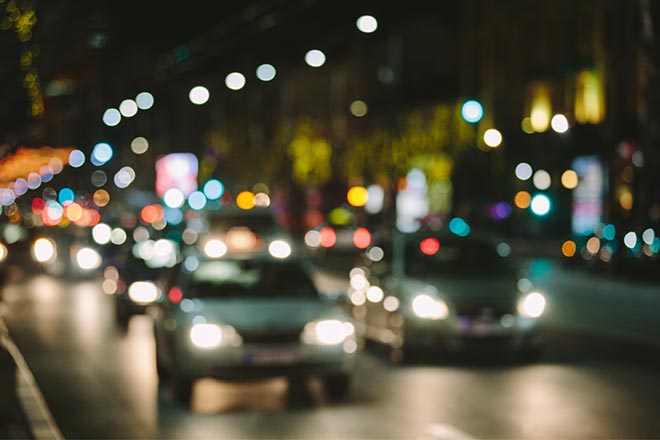 Blurred night-time city traffic with haloes around every headlight and street light